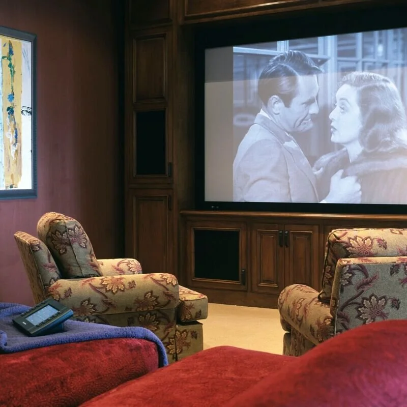 Photograph of a home theatre with large screen and comfortable seating.  A room idea for when the kids move out.